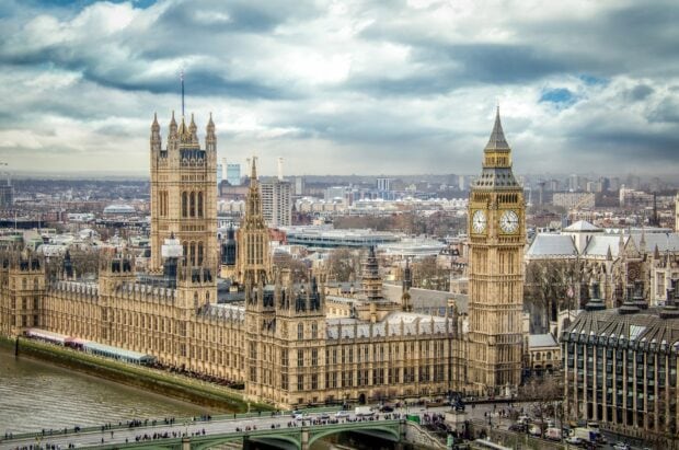 The iconic Big Ben clock tower in London stands prominently over the cityscape on a cloudy day