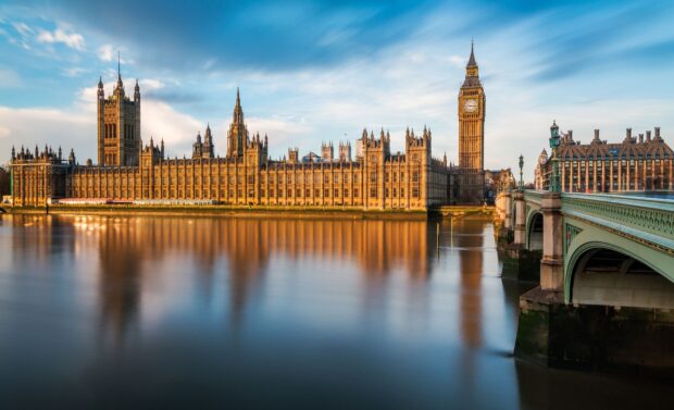 The iconic Big Ben clock tower and palace along the river at sunset with clear skies