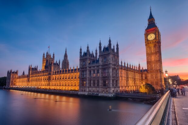 The iconic Big Ben clock tower and the Palace of Westminster lit up at sunset in London