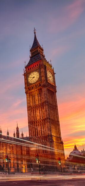 Big Ben tower illuminated at sunset with city lights in the background