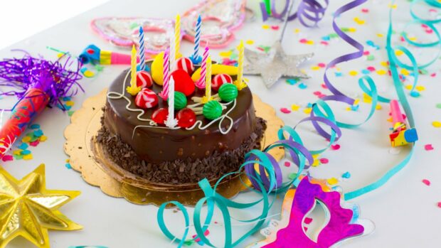 A colorful birthday party setup with a chocolate cake and festive decorations on a table