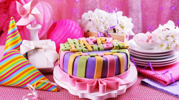 A colorful birthday cake with happy birthday letters and striped party hats on a decorated table