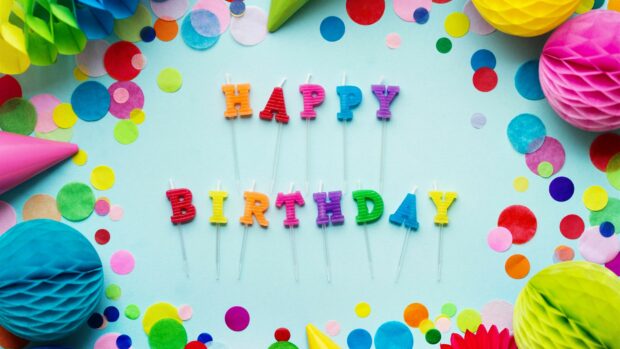Colorful birthday party candles spelling happy birthday with confetti on blue background