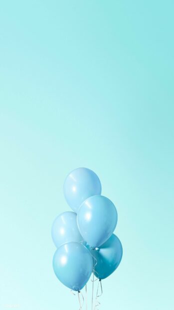 Blue birthday party balloons floating on a light blue background