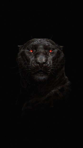 A close up of a black panther with glowing red eyes in dark lighting
