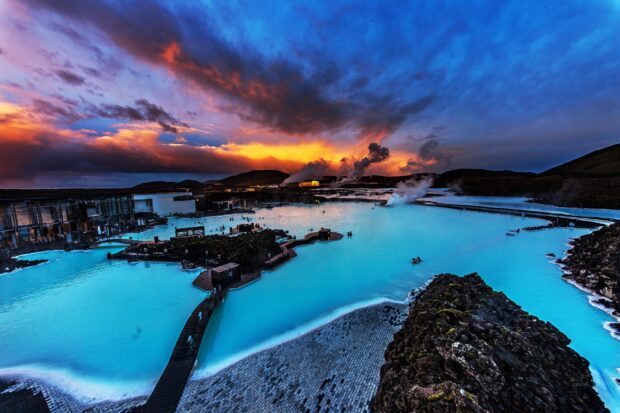 Blue Lagoon Iceland geothermal spa with vibrant blue waters under dramatic sunset sky