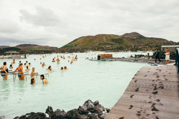 People enjoying the geothermal lagoon and volcanic landscape at Blue Lagoon Iceland