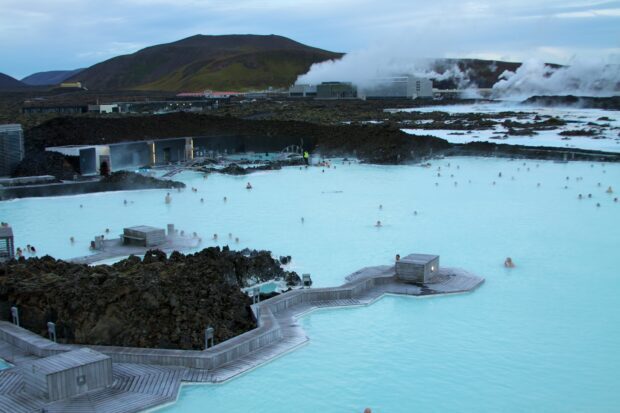Visitors relaxing in the geothermal Blue Lagoon Iceland spa surrounded by volcanic landscape