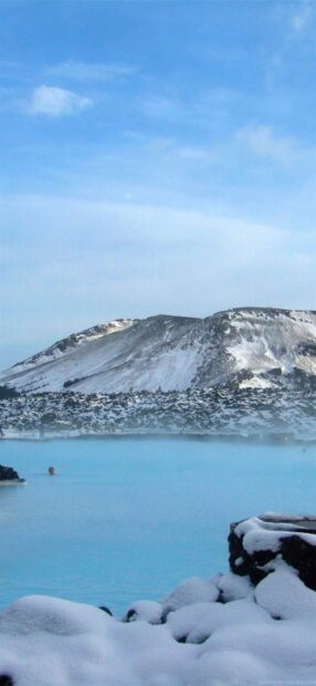Snowy volcanic landscape with Blue Lagoon Iceland steam rising