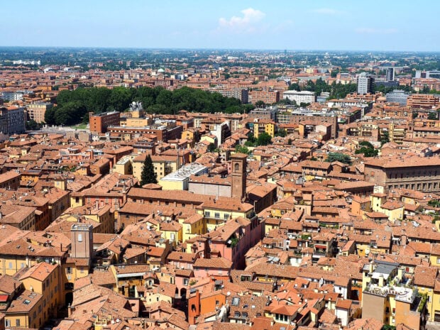 A panoramic view of Bologna city with historic buildings and terracotta roofs under a clear sky