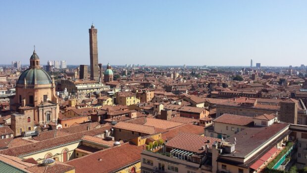 Historic Bologna cityscape with medieval towers and terracotta rooftops in clear sky