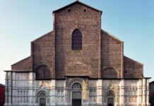 The historic facade of a cathedral in Bologna showcasing detailed architecture and ancient bricks