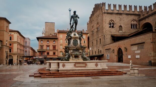 The Neptune statue in Bologna city center with historic buildings around