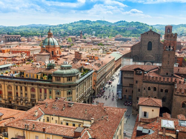 A panoramic view of Bologna cityscape featuring historic buildings and rooftops in clear daylight