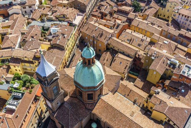 Aerial view of Bologna rooftops with a prominent dome and bell tower in the city center
