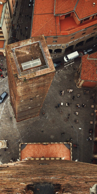 Aerial view of historic brick towers and streets in Bologna city center