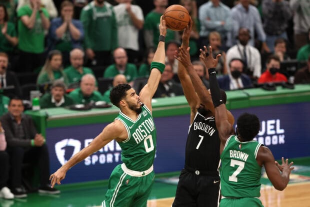 Boston Celtics player jumping to block a Brooklyn player shooting the ball during a basketball game