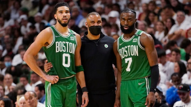 Boston Celtics players and coach standing together during a basketball game
