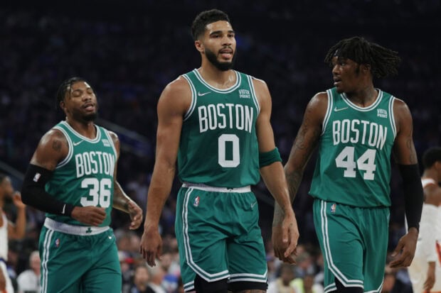 Boston Celtics players wearing green jerseys walking on the court during a game