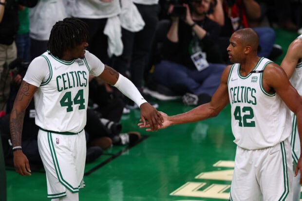 Two Boston Celtics players celebrating on court during the game with visible jersey numbers 44 and 42