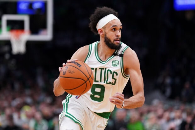 Boston Celtics player dribbling the basketball during a game in a Celtics uniform