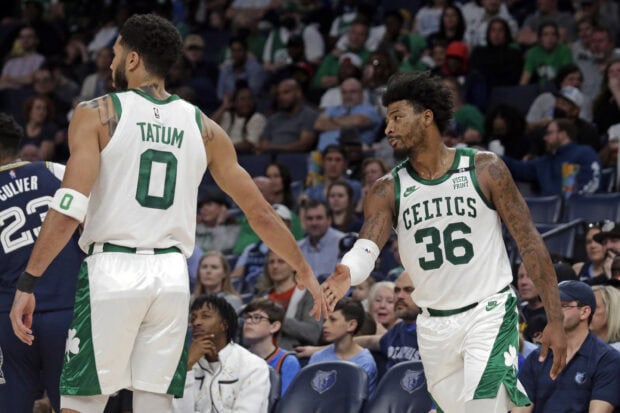 Jayson Tatum and Marcus Smart of Boston Celtics celebrating during a basketball game in front of fans