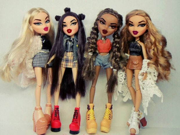 Four Bratz Dolls with stylish outfits and long hair standing together
