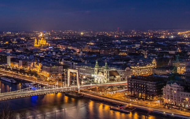 Night view of Budapest cityscape with illuminated buildings and bridges over the river