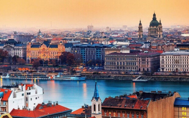 Historic buildings and river view in Budapest cityscape at sunset with vibrant colors