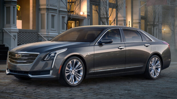 A sleek gray Cadillac parked on a cobblestone street near urban buildings