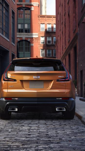Rear view of a Cadillac XT4 parked on a cobblestone street in an urban setting