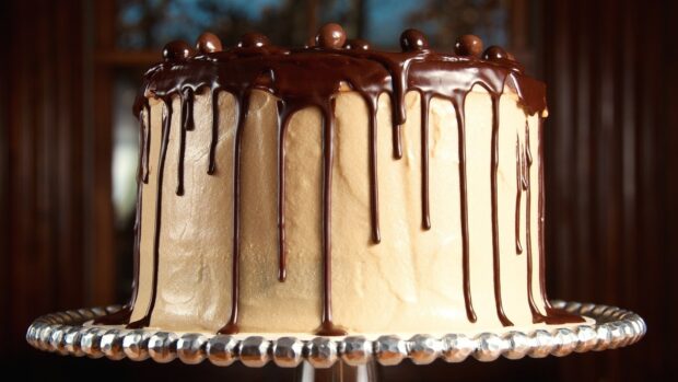 A delicious cake covered with smooth frosting and dripping chocolate ganache