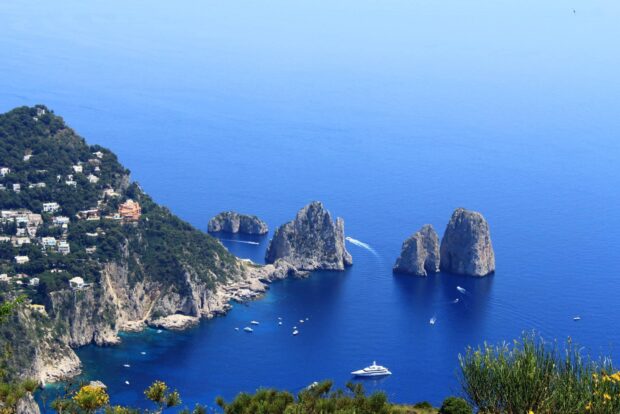 A scenic view of Capri Island with rocky cliffs and clear blue sea