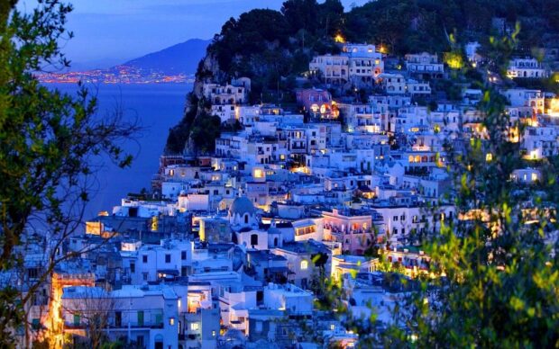 Night view of Capri Island with illuminated buildings and coastal landscape