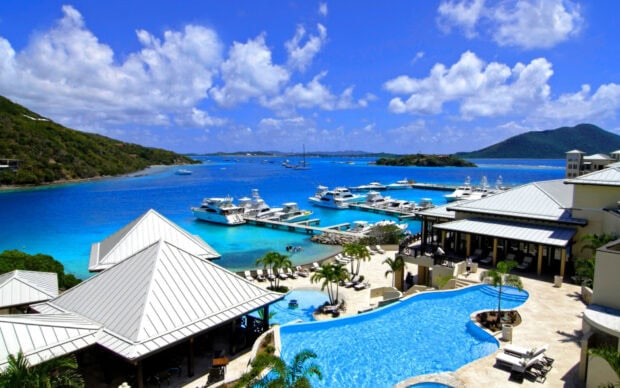 Stunning Caribbean Islands marina with yachts and resort pool under a vibrant blue sky
