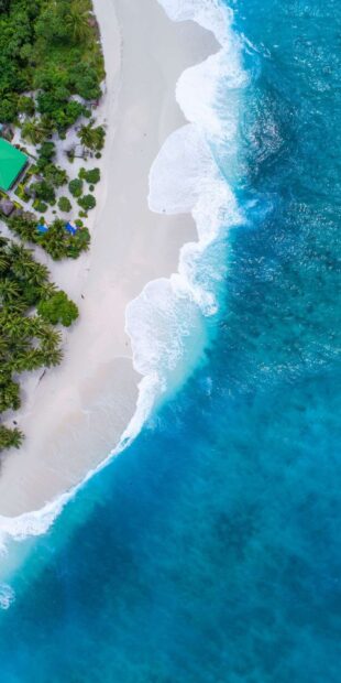 Aerial view of Caribbean Islands with turquoise sea and white sandy beach surrounded by lush green trees
