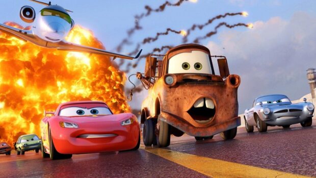 Rusty tow truck and red racing car from Cars Disney run on race track with explosion behind