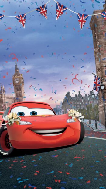 A red Cars Disney character decorated with flowers in London city with confetti and British flags