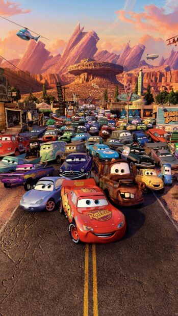 The cars Disney characters gather on a road with scenic desert mountains in the background