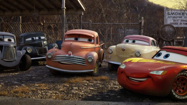 A group of Cars Disney characters posing happily in a rustic outdoor setting