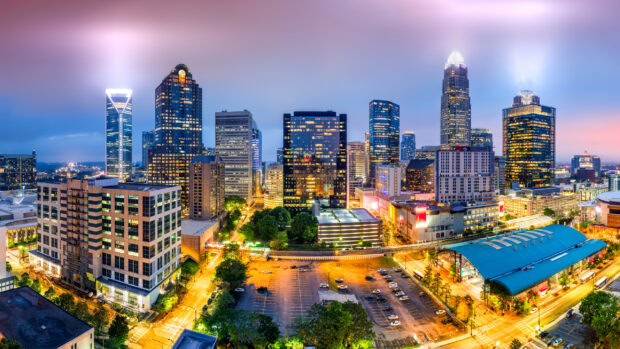 Charlotte skyline at dusk showing illuminated skyscrapers and cityscape with vibrant colors