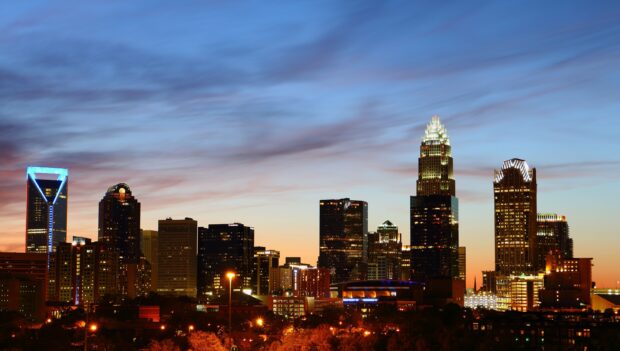 Evening cityscape with Charlotte skyline lit up against a colorful sky