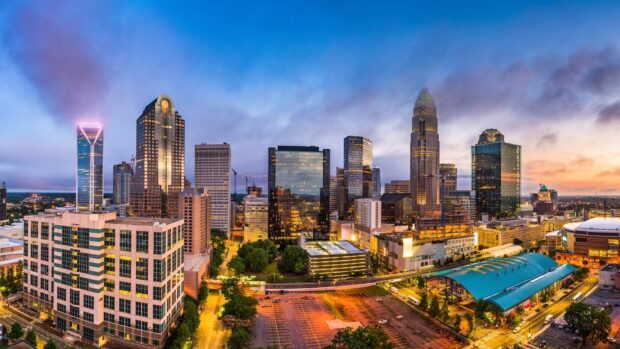 Charlotte skyline with tall buildings illuminated during sunset showing cityscape and urban life