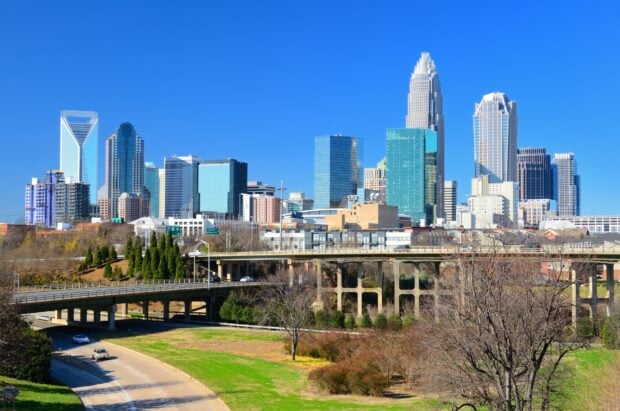 Clear blue sky over Charlotte skyline with modern skyscrapers and urban greenery