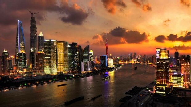 The Shanghai skyline in China at sunset with the river and illuminated skyscrapers