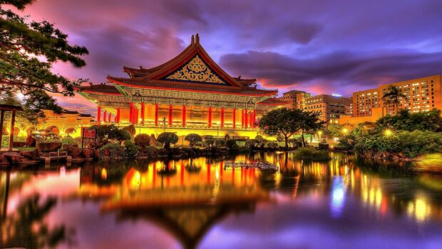 Traditional China architecture reflected in water during sunset with vibrant sky colors