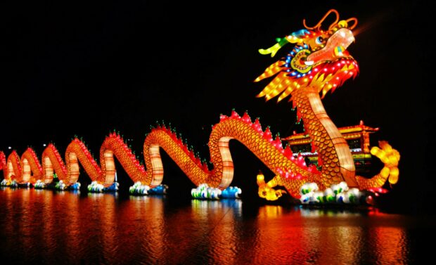 A colorful traditional Chinese dragon lantern floating on water at night