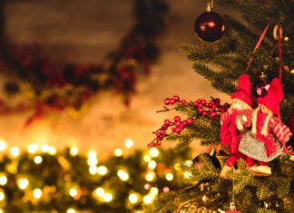 Christmas tree decorated with red berries and ornaments in a cozy room with warm lights