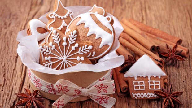 Gingerbread cookies with cinnamon sticks and star anise on wooden table featuring cinnamon elements