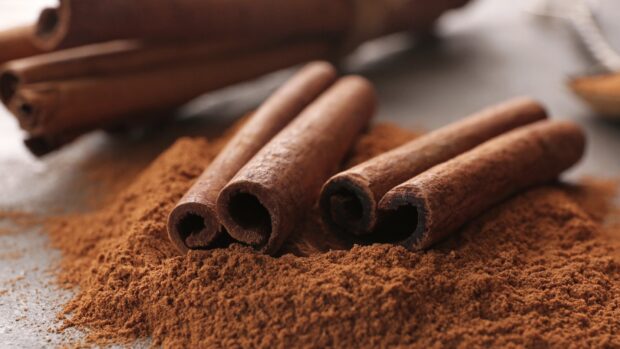 Close up of cinnamon sticks on a heap of cinnamon powder
